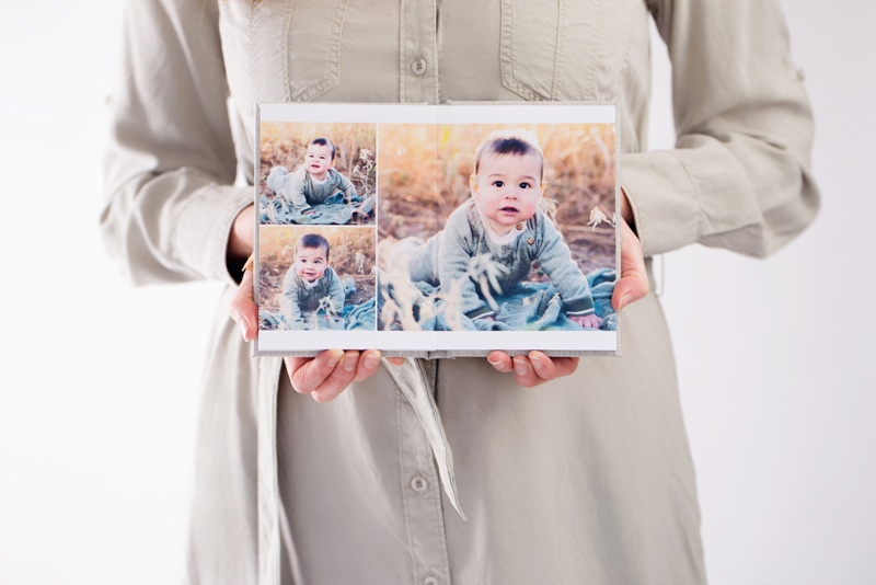 Newborn Photographer, a woman's hands holds a print photo of a baby