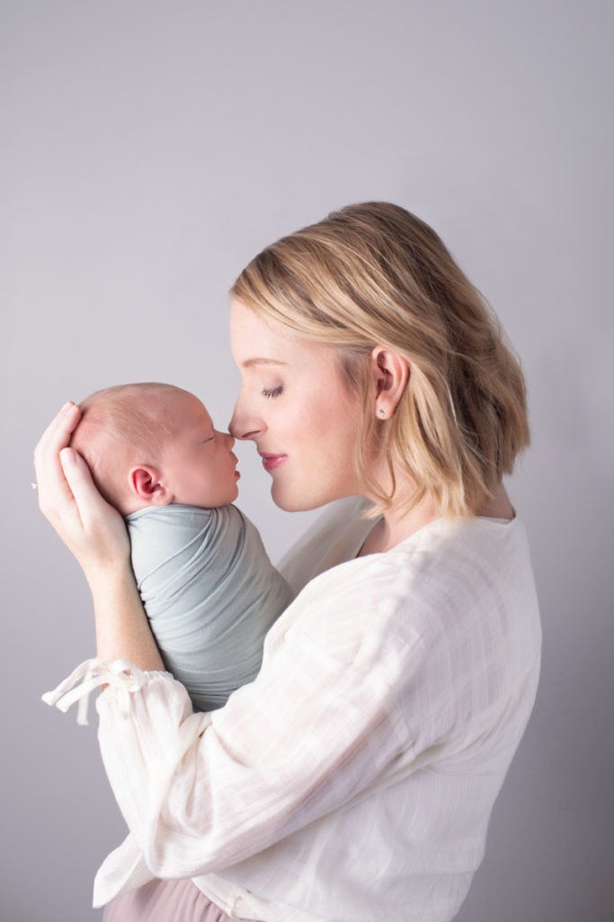 Newborn Photography, a mother holds her little baby son close, nose to nose