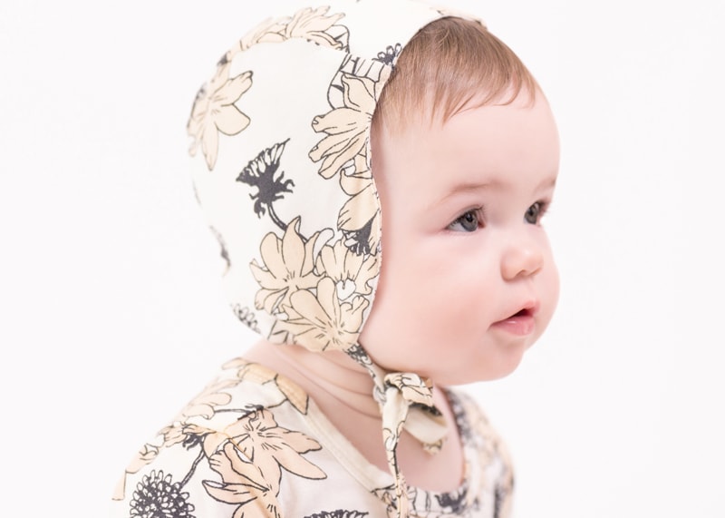 milestone photography, baby girl wears a bonnet covered in floral patterns