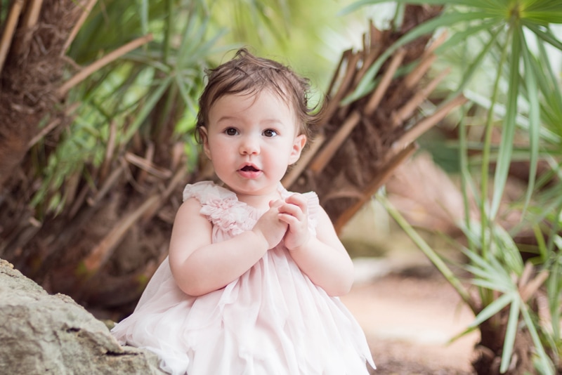 milestone photography, baby girl sits on a rock outdoors