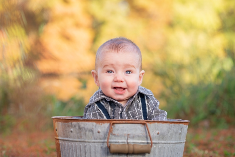 milestone photography, a little smiling baby boy sits in a tin wash bin outside