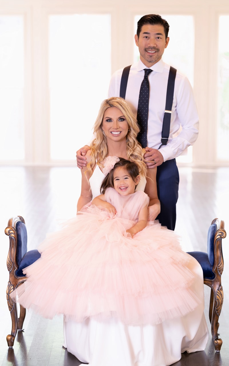 Family Photographer, mom and dad are all dressed up with their little girl on mom's lap