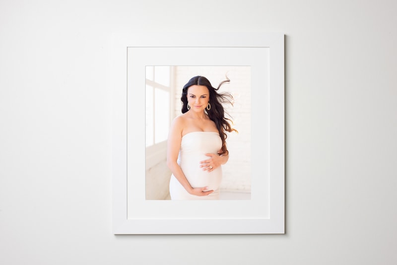 Maternity Photographer, a pregnant woman appears on photograph in a white frame