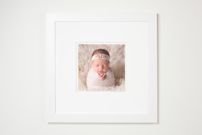 Newborn photographer, a photo print is framed, it contains a picture of a baby